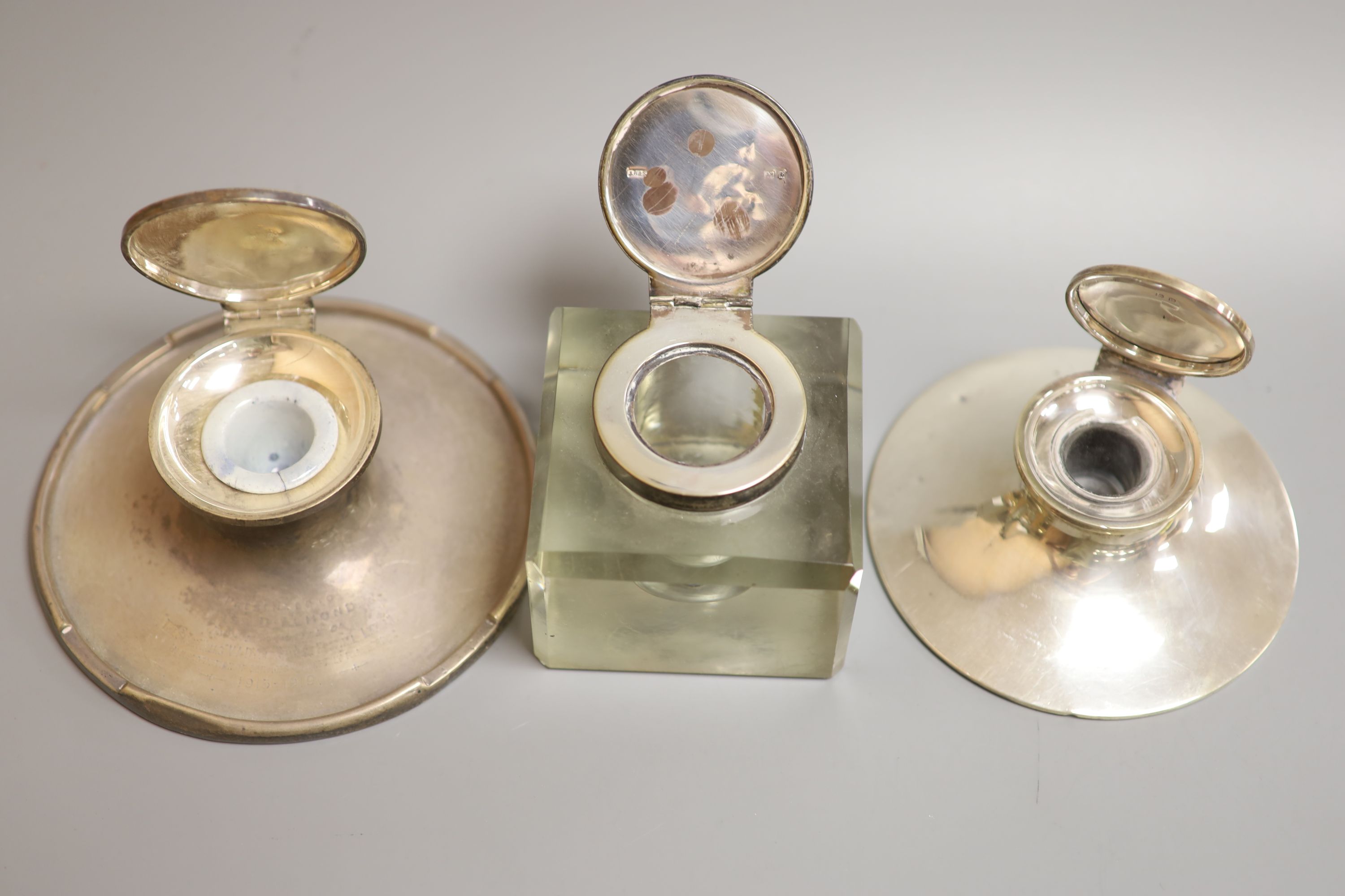 Three assorted silver mounted inkwells including two capstan, largest 15.2cm.